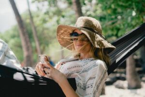a happy woman wearing sun glasses and a hat