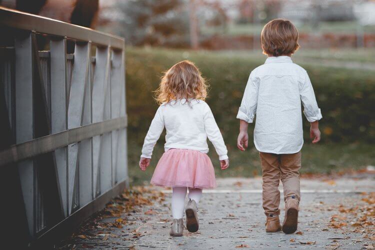 a young boy and a young girl walking together