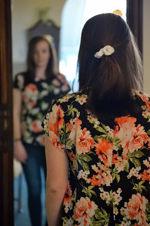 A woman looking herself in the mirror