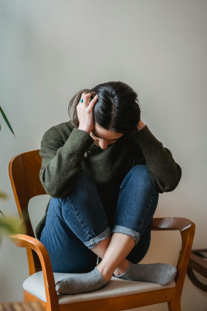 girl sitting in a chair with her head in her hands stressed out